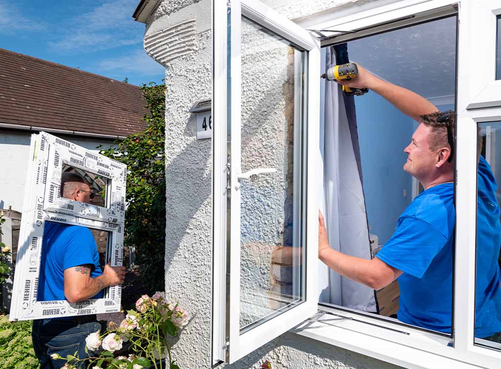 A Man Holding A Drill And A Window