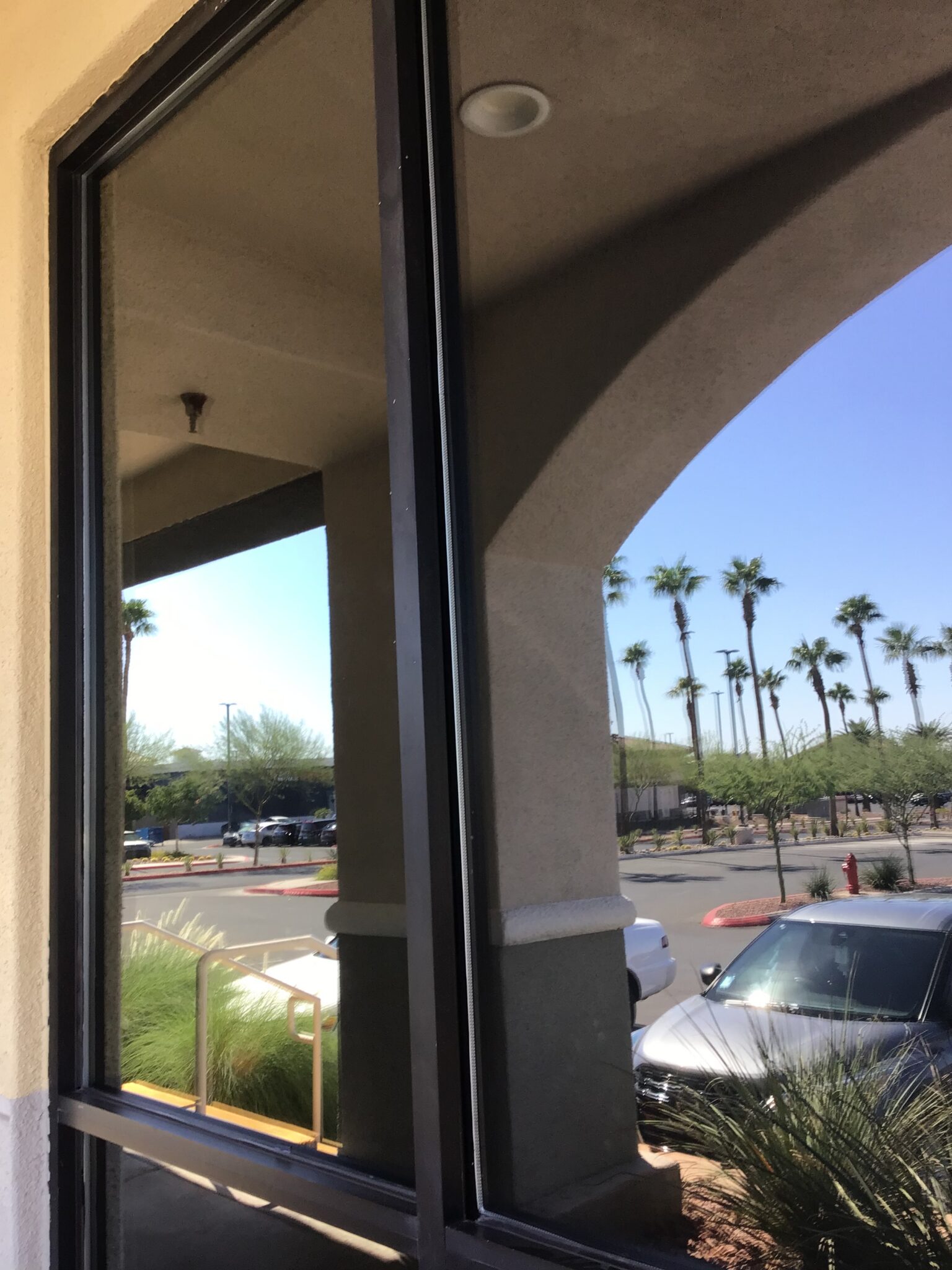 Tinted storefront glass reflecting the street