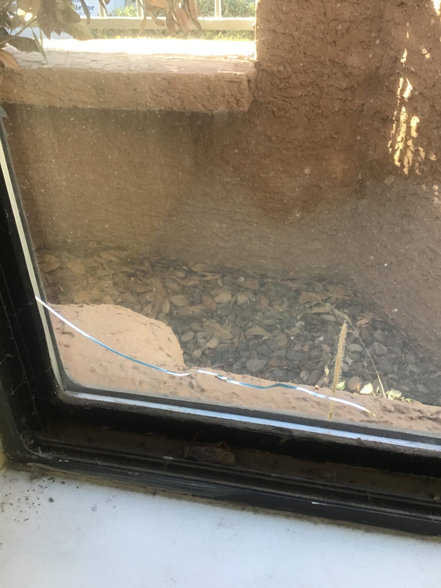 A worn, dirty sliding patio door with a cracked pane
