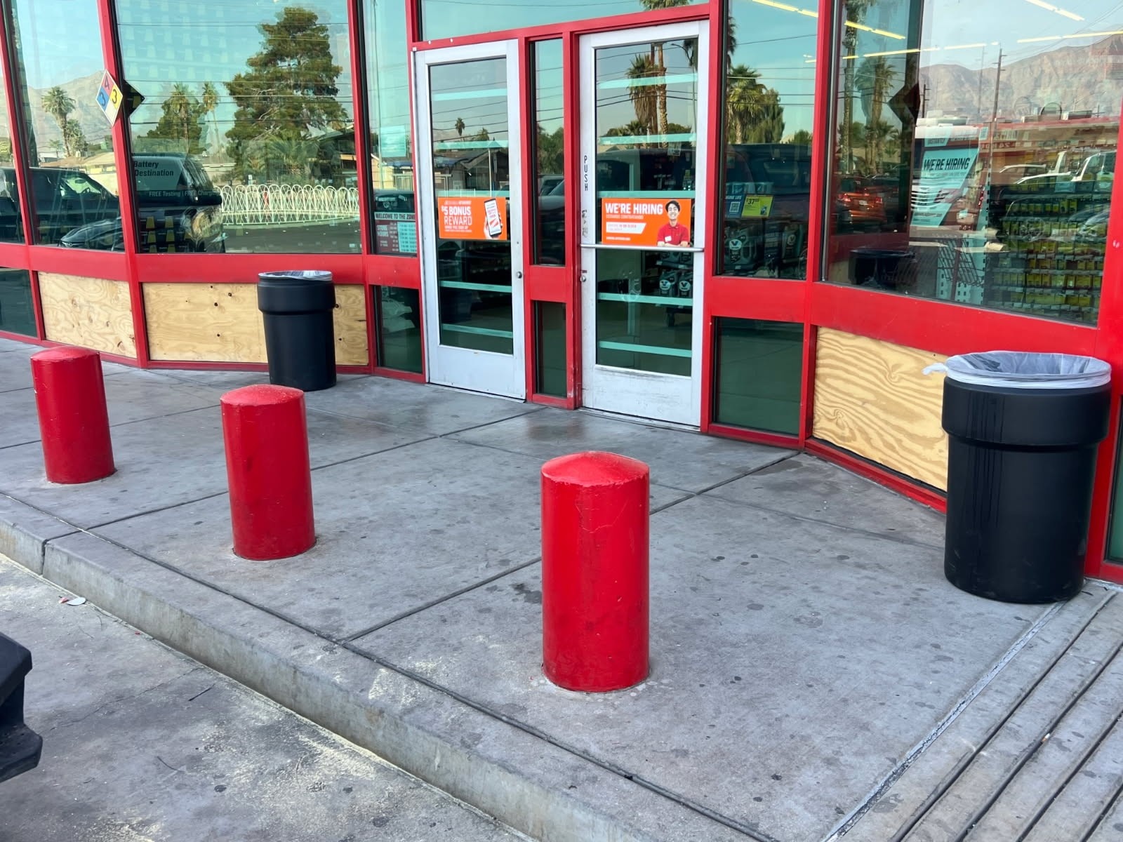 An AutoZone storefront with boarded-up glass
