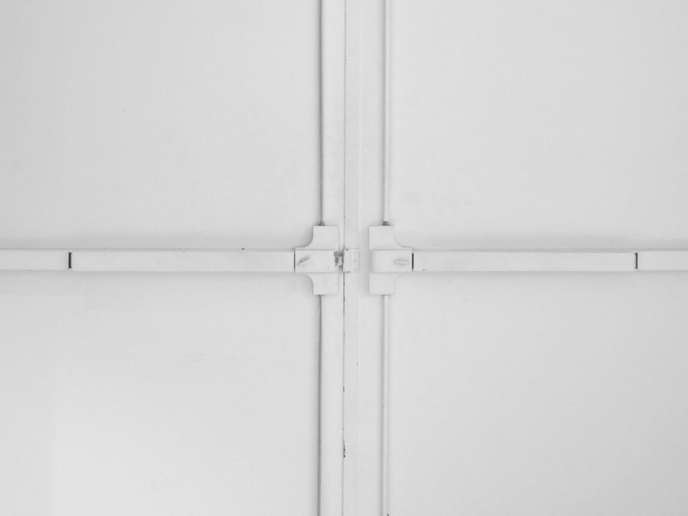 White double exit doors with panic bars under an exit sign