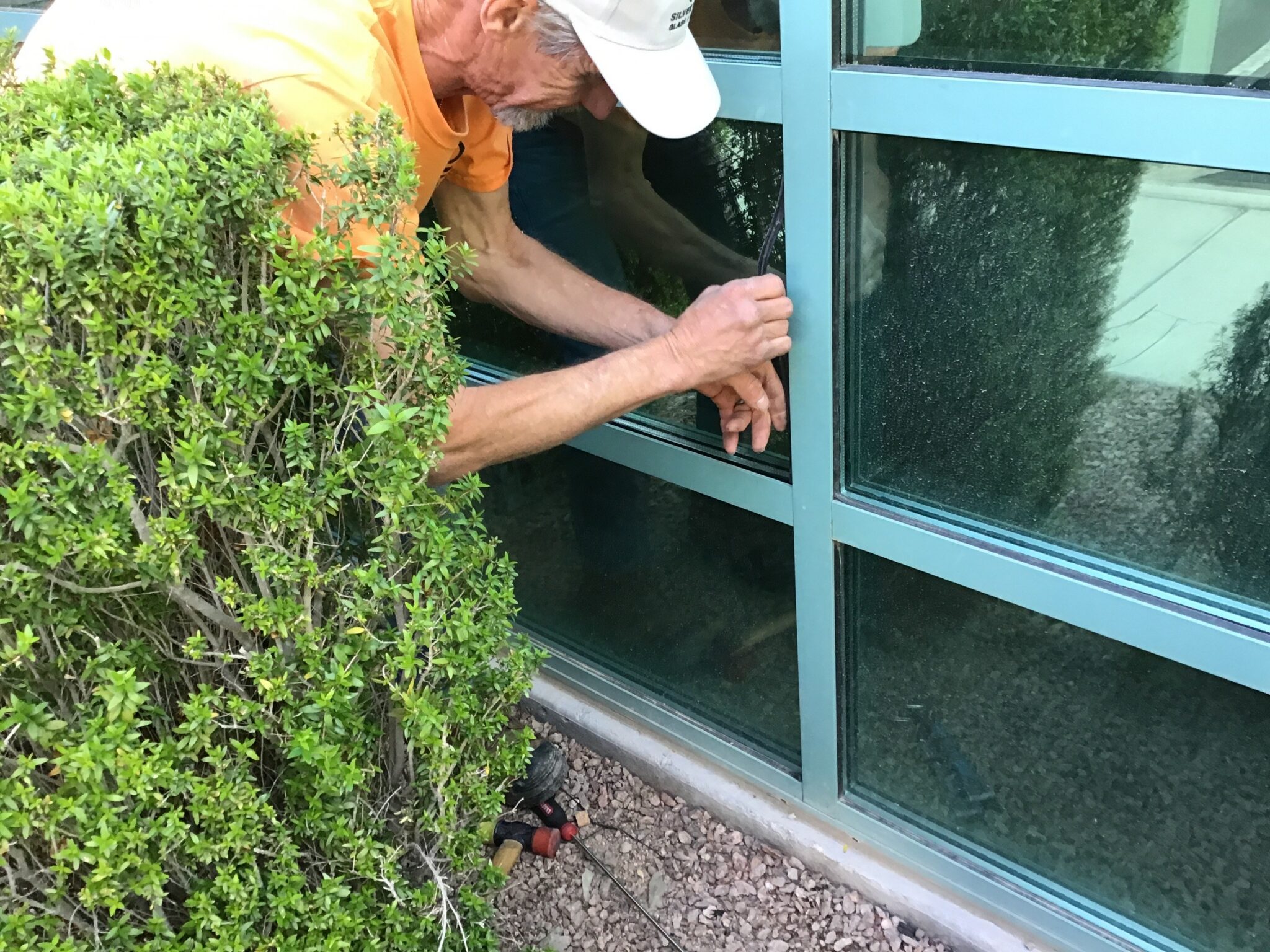 Window Replacement & Installation in Las Vegas 1 A glazier working on a window from outside a Las Vegas home
