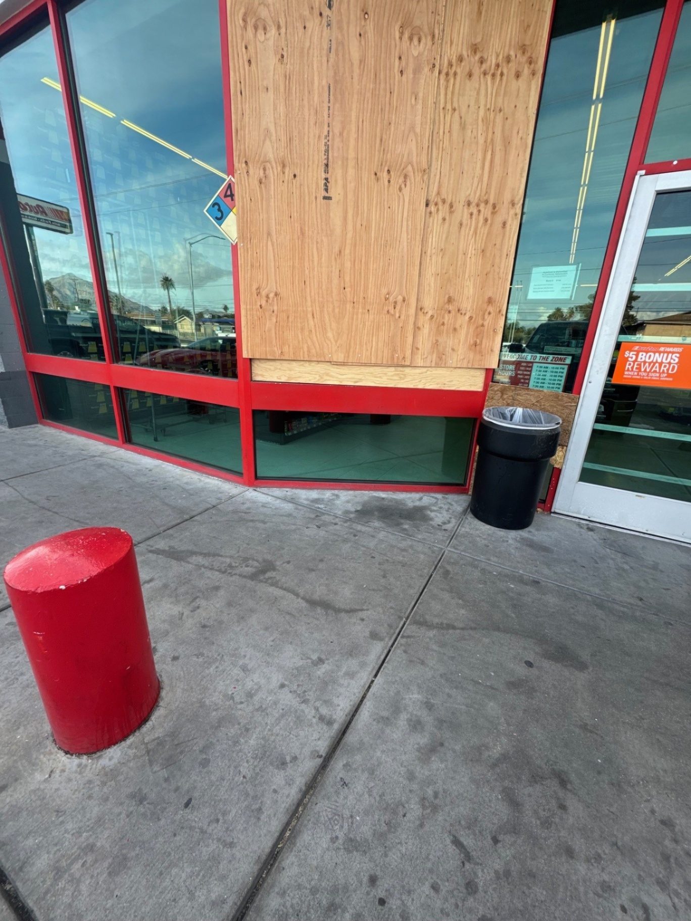 Glazier setting plywood over a storefront opening