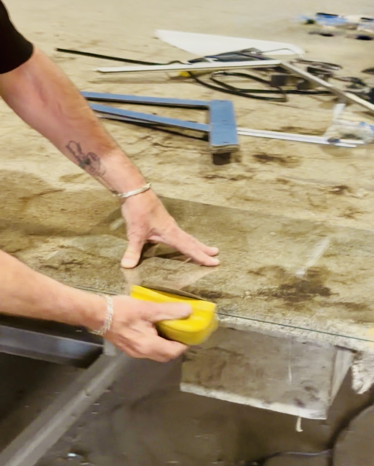 Custom Glass Cutting in Las Vegas: Any Size, Any Shape 6 Hands seaming the edge of a glass panel with a hand tool in the shop