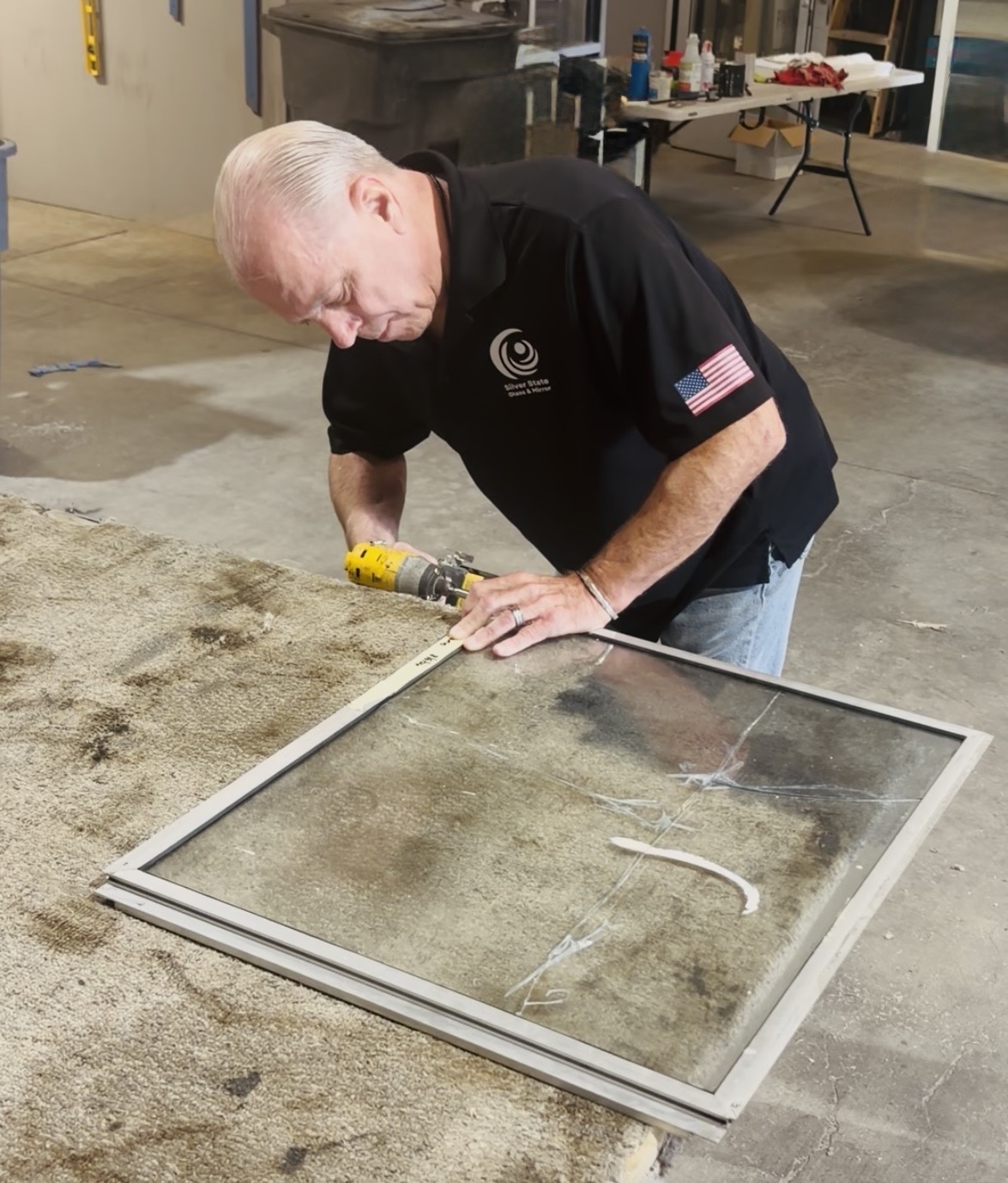 Window Screen Repair & Replacement in Las Vegas 3 A Silver State worker fitting a window screen at the shop bench