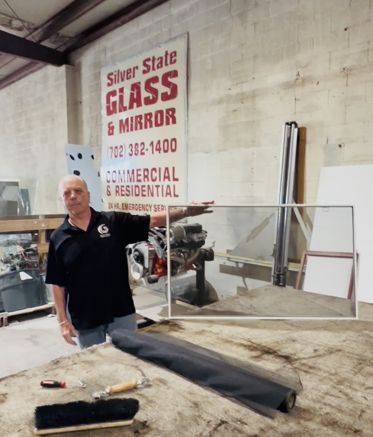 Window Screen Repair & Replacement in Las Vegas 4 A Silver State worker holding a finished window screen by the shop sign