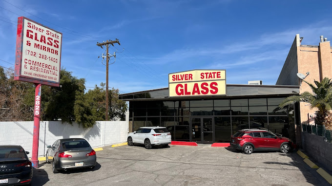 Exterior view of the Silver State Glass & Mirror building, showcasing the company's signage and parking lot on a sunny day.