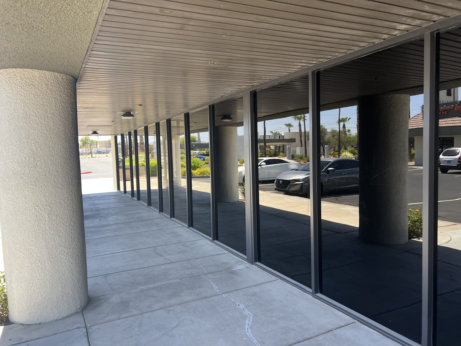 Glass Project Gallery Las Vegas 4 A covered walkway lined with tinted storefront glass