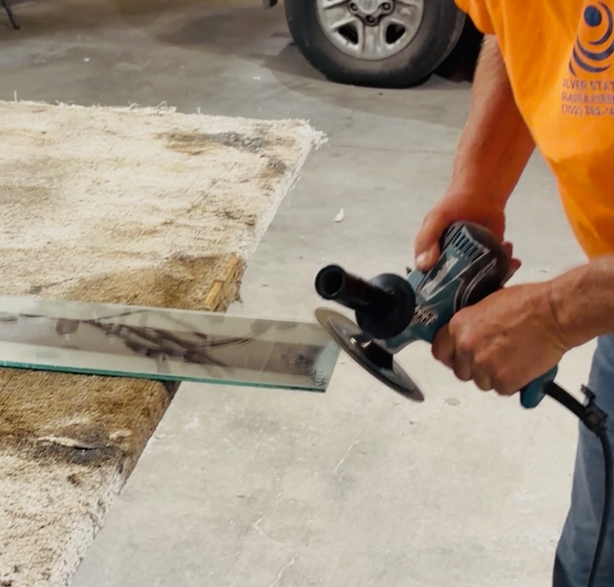Custom Glass Cutting in Las Vegas: Any Size, Any Shape 5 A glazier edge-grinding a glass panel on the cup wheel
